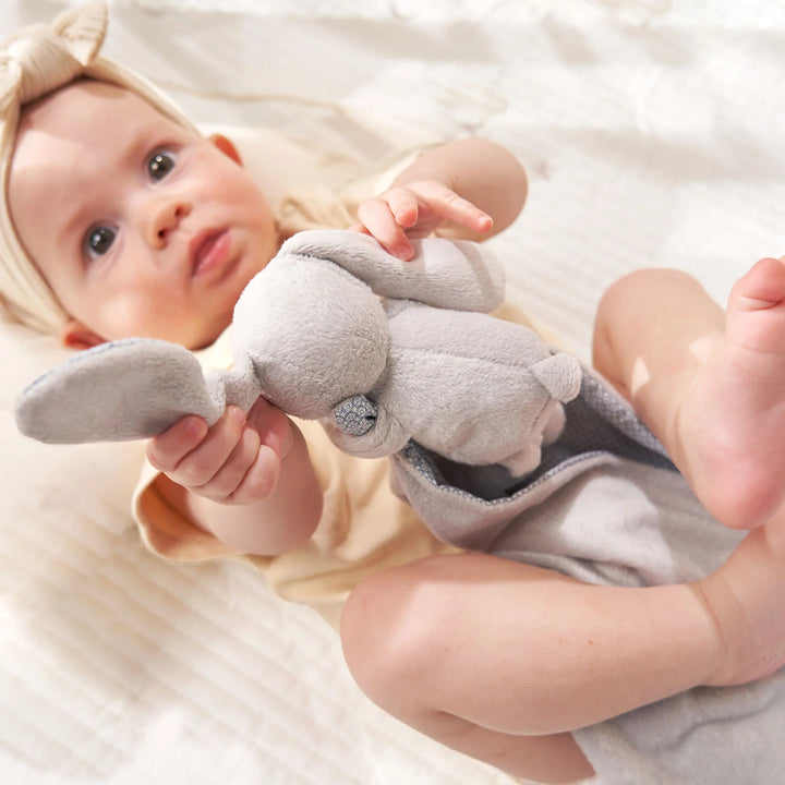 A cute baby is playing with The bunny comforter is made of soft velvet and has a patterned reverse.