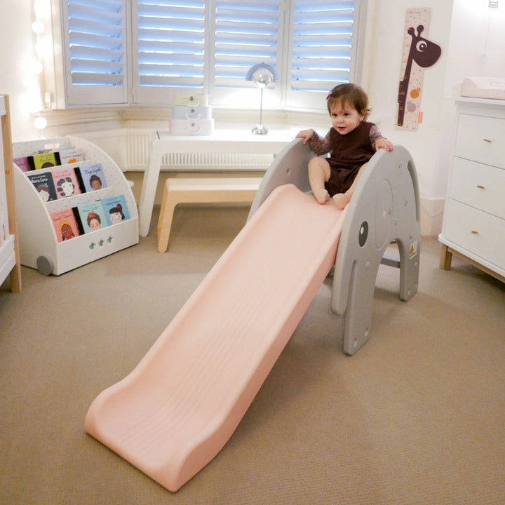 Happy children are having fun on a pink elephant-shaped kids slide.