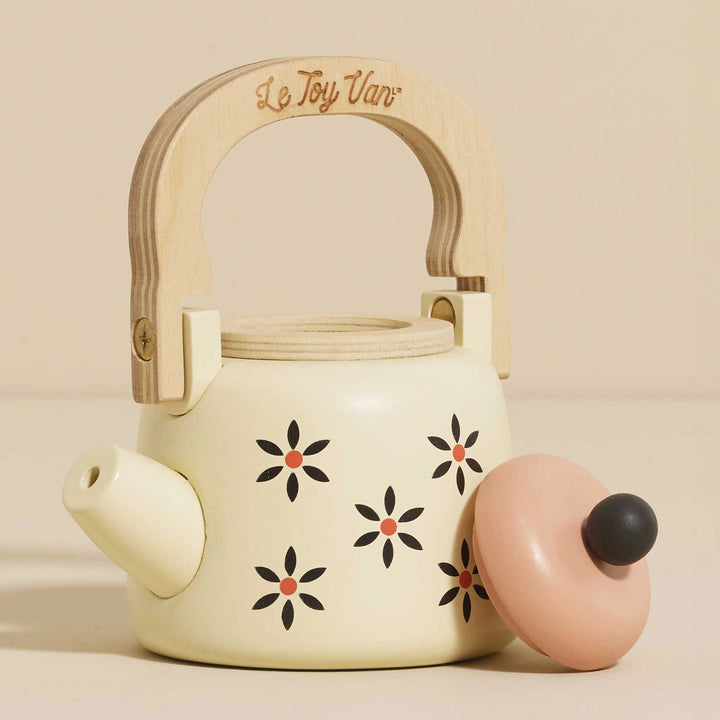 Wooden toy kettle with floral details and removable lid.