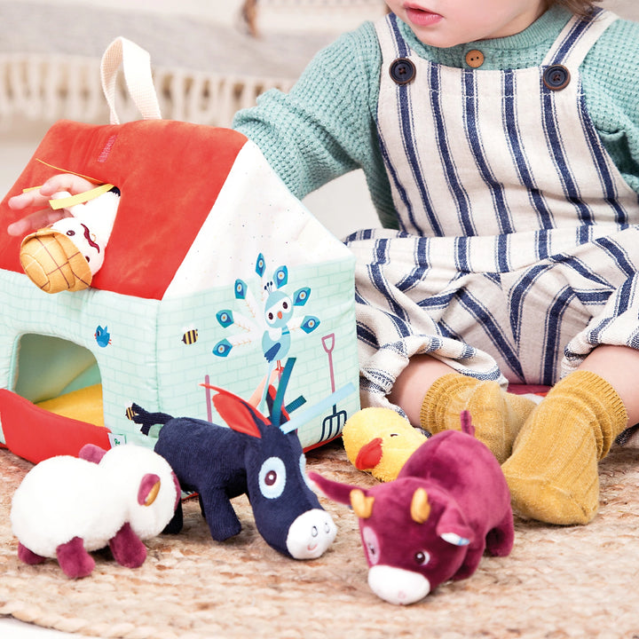 Child playing with Lilliputiens My First Farm soft dollhouse farm.