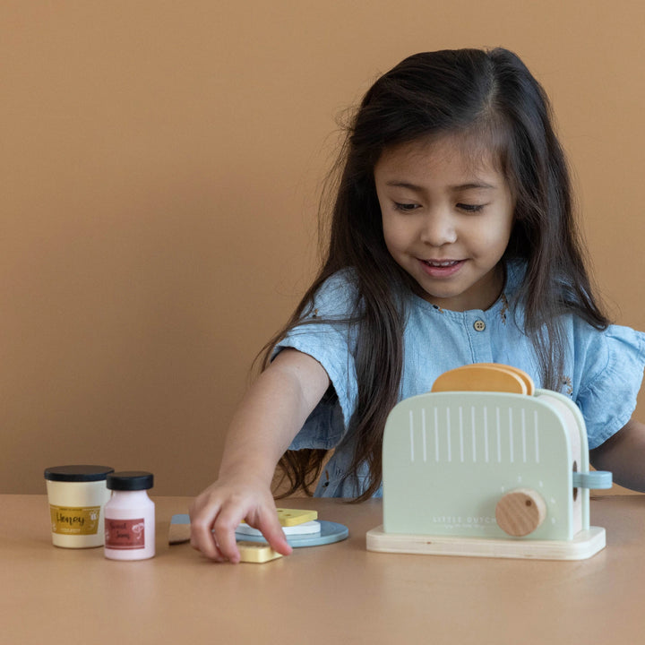 Child playing with Little Dutch Wooden Toaster Set.