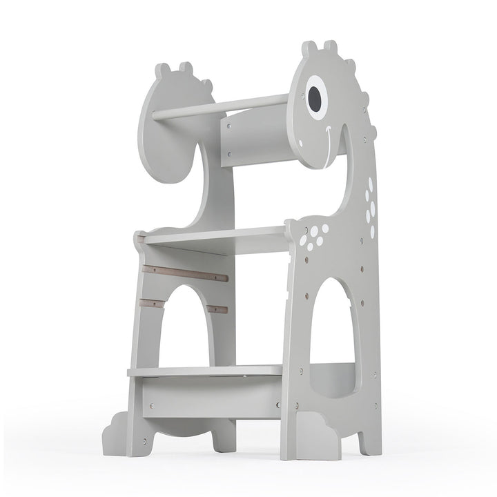 Angled view of the Dino toddler learning tower, highlighting its adjustable height, sturdy steps, and fun dinosaur shape to promote safe independence in the kitchen.