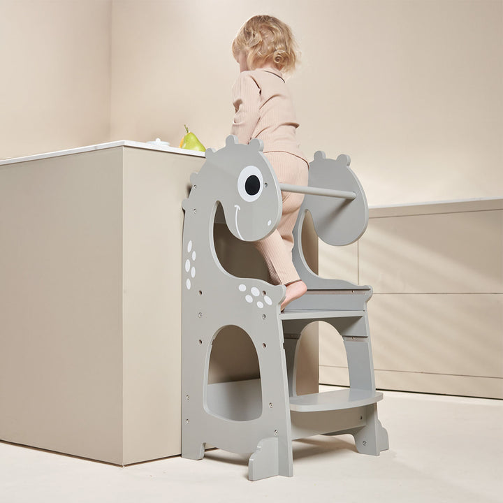 Back view of a toddler climbing the Dino Grey learning tower, demonstrating its secure and child-friendly design, ideal for kitchen learning and family bonding.