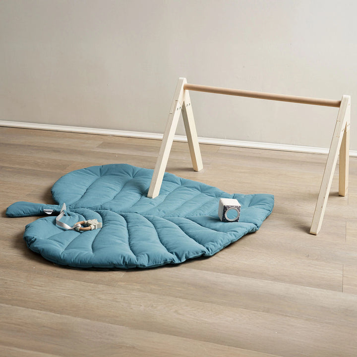 Eco-friendly infant mat with wooden frame and hanging toys.