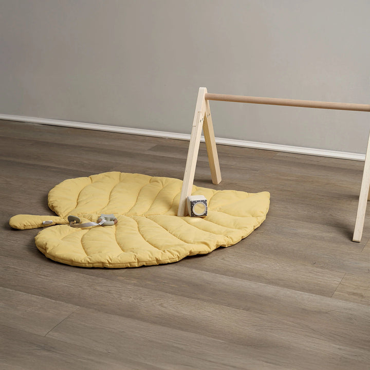 Leaf-shaped padded playmat with baby-safe toys.