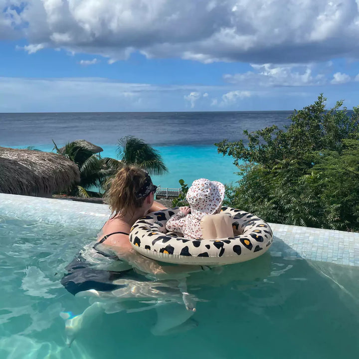 Parent and baby interacting with the swim float - Demonstrating the float's ample space that allows the baby to move freely and enjoy the water.