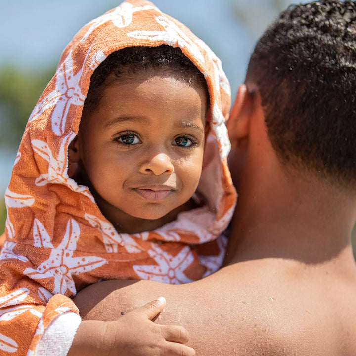 Child wearing the Beach Poncho with Starfish design at the beach - Showcasing the charming starfish pattern and summery look.