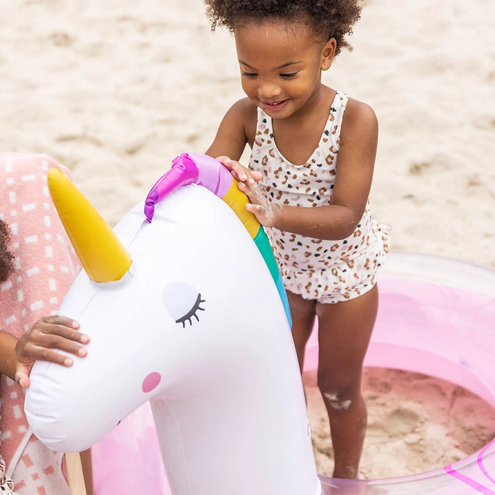 Group of kids at a pool party enjoying their unicorn-themed swim rings.