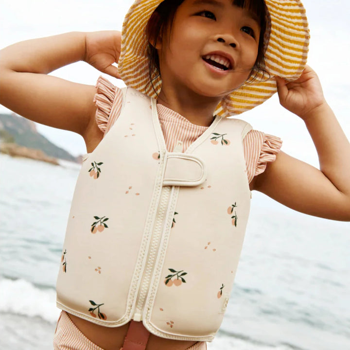 The Dove Swim Vest being worn by a child during swim lessons, emphasizing its role in supporting swimming skill development and water safety education.