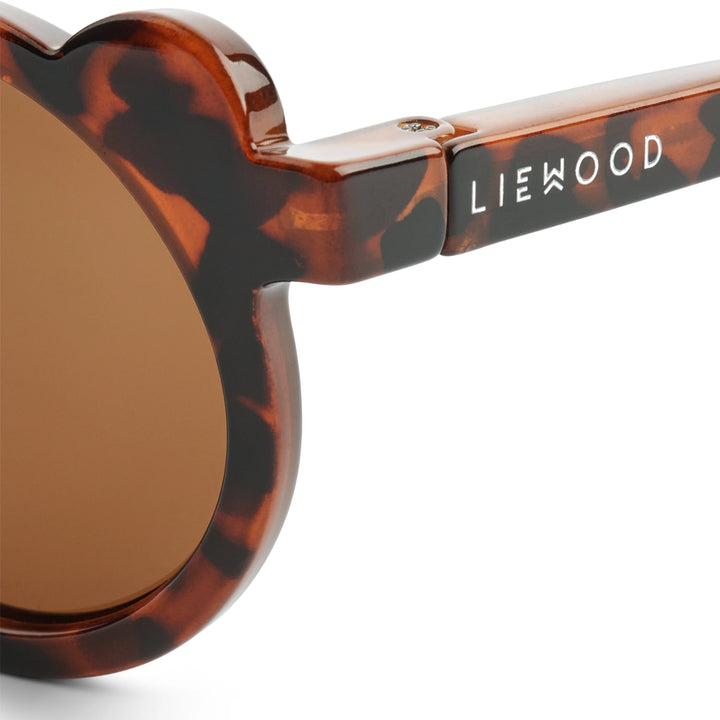 Detail shot of the subtle silver Liewood logo on the temple of Darla Mr. Bear sunglasses