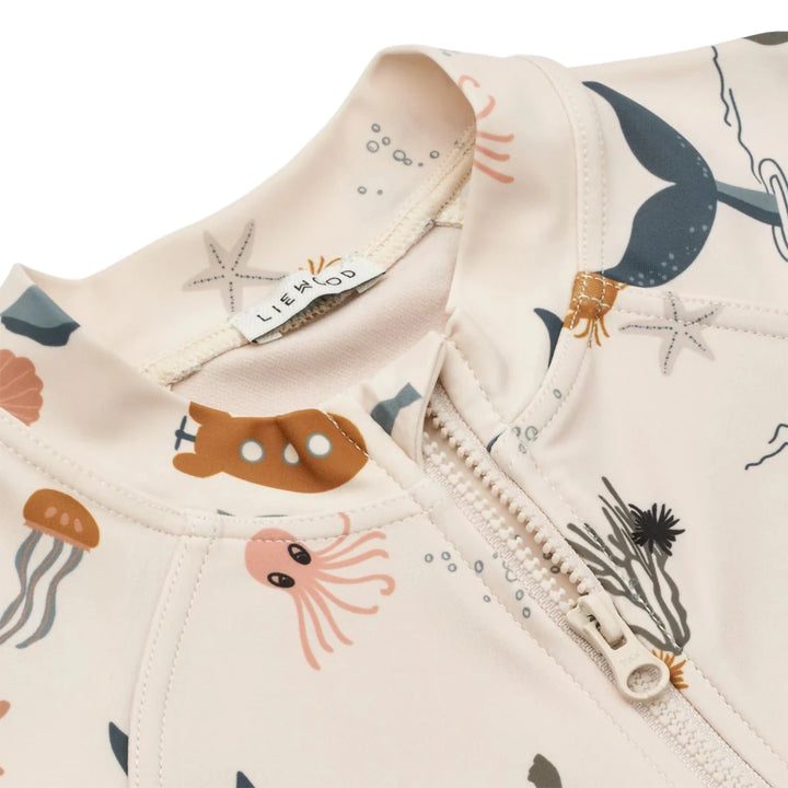 This is a close-up of the Jumpsuit in a vibrant sea creature print, showcasing its high collar and front zipper.