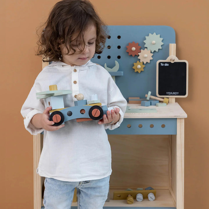 A wooden workshop for kids with tools and building materials that are safe for toddlers.