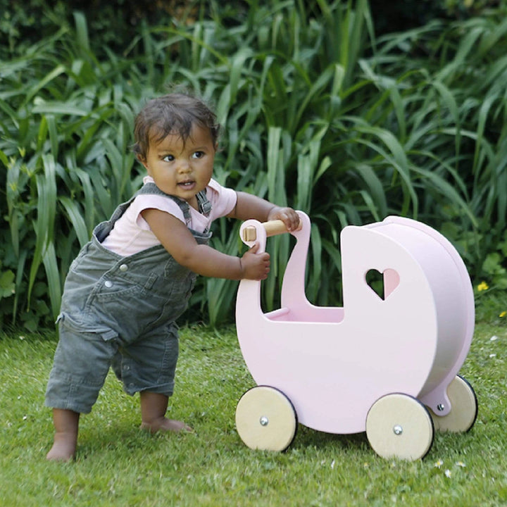 A cute baby is playing with pram