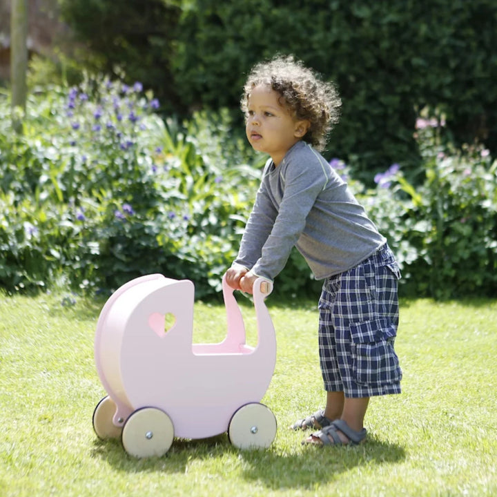 A boy is playing whit doll pram